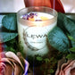 Lit 'Confidence' Candle in frosted glass, with soft flame and dried floral accents, creating a calming atmosphere.