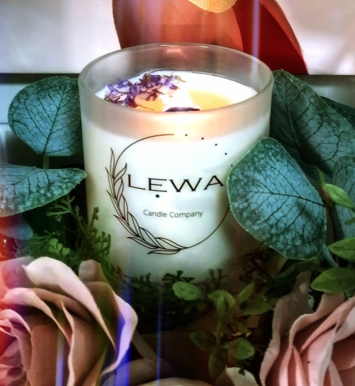 Lit 'Confidence' Candle in frosted glass, with soft flame and dried floral accents, creating a calming atmosphere.